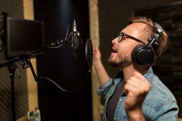 man with headphones singing at recording studio