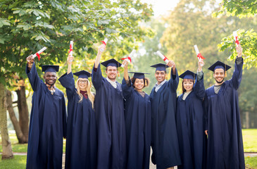 Wall Mural - happy students in mortar boards with diplomas