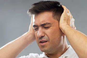 Poster - close up of man suffering from noise closing ears