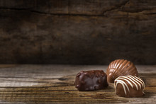 Three Different Types Of Chocolate Candy Over Rustic Wood