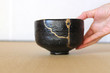 金継された抹茶茶碗を右手で日本畳の上に置く