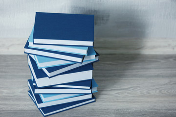 Canvas Print - Stacked books on gray wooden floor in room