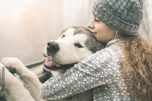 Photo Image of young girl with her dog, alaskan malamute, outdoor