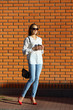 © Olha Afanasieva - Young woman standing near brick wall
