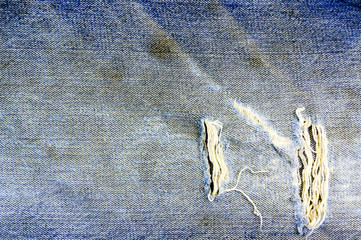 Torn and shabby old blue jeans background