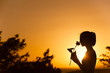 © kieferpix - Woman smelling a rose against a beautiful sunset. Romantic gift concept.