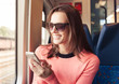 © kieferpix - Beautiful young woman texting with her smart phone on a public train.