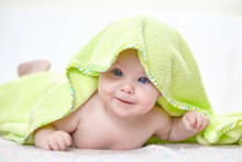 Happy Baby Under A Green Towel After Bathing