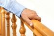 hand of senior man over a wooden railing