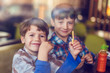 © sakkmesterke - Little boys eating french fries in fast food restaurant