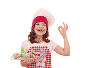 Wall Mural - happy little girl cook with muffin and ok hand sign