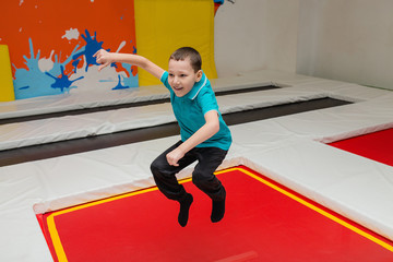 Child boy jumping on trampoline in fly park