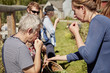 © Mint Images - A group of people tasting seeds and plants on the foraging course.