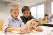 © Syda Productions - happy children building robots at robotics school