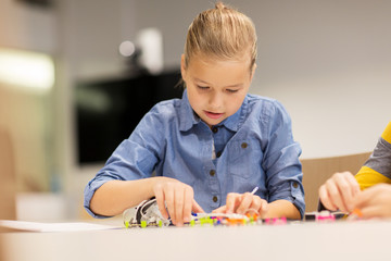 Wall Mural - happy girl building robot at robotics school
