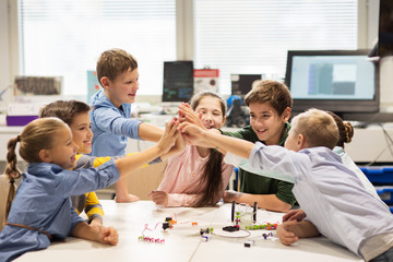 happy children making high five at robotics school