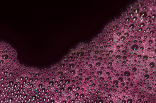 Bubbles Of Red Wine Closeup. Alcoholic Background