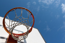 Worn But Repaired Basketball Hoop Net Against The Blue Sky.