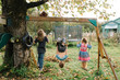 © Breanna Peterson - Siblings playing on swings in garden