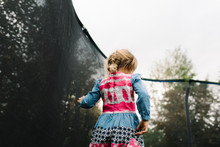 Young Girl Standing Still On Trampoline 