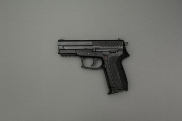 Wall Mural - Black gun on a gray background