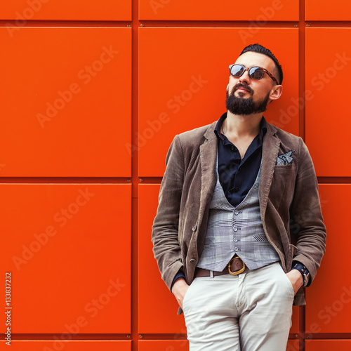 Young Confident Hipster Man With Beard In Glasses Posing On The