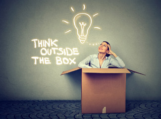 Think outside box. Woman coming out of box with great idea