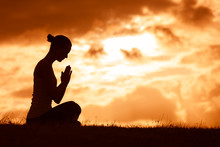 Silhouette Of Woman Praying. 