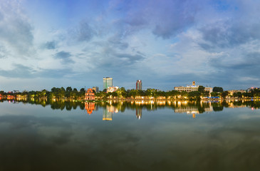 Wall Mural - Hoan Kiem lake panorama view at sunset period with ancient Turtle Tower and Hanoi post office (Buu Dien Ha Noi in Vietnamese) . Hoan Kiem lake (Sword lake or Ho Guom) is center of Hanoi