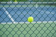 © Hanoi Photography - Tennis ball on metal wire against tennis court. Concept of tennis protection equipment