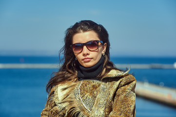 Fashionable girl in glasses on the background of the sea