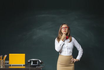 Thoughtful young woman on chalkboard background