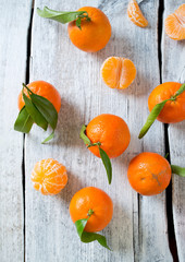 Poster - tangerines with green leaves on turquoise wooden background