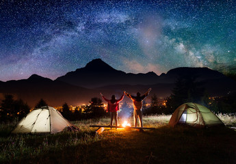 night camping. couple tourists standing and holding hands lifting up from enjoying the beautiful vie