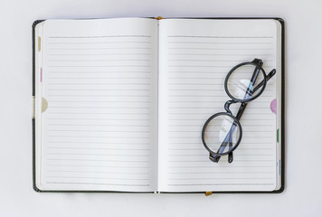 Wall Mural - Eyeglasses on blank notebook 