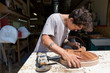 © Connect Images - Guitar maker manufacturing guitar in workshop