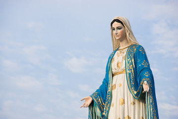 Virgin mary statue with blue sky background