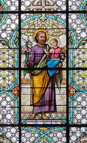 Naklejka dekoracyjna VIENNA, AUSTRIA - DECEMBER 19, 2016: The St. Joseph on the stained glass of church Mariahilfer Kirche by prof. Rudolf Geyling (1897) in workroom Carl Geylings Erben.