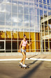 © evgeniy_regulyan - Beautiful hipster girl in a jeans shorts and pink shirt walking with skateboard near the green park, sexy style, adult, long legs, brunette, white shoes, sexy model, posing on camera