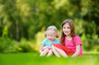 © MNStudio - Two cute little sisters having fun together on the grass on summer day