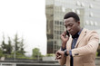 © Cavan Images - Businessman checking the time while using smart phone in city