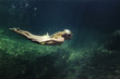 © Cavan Images - Side view of woman swimming in sea