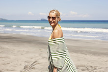Portrait Of Happy Woman Standing On Beach During Summer Vacation
