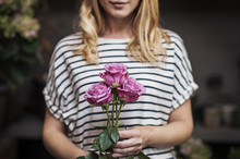 Midsection Of Woman With Pink Roses In Flower Shop