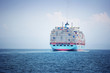 © Cavan Images - Container ship loaded with cargo containers sailing on sea against sky