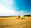 © Maryia Bahutskaya - Working Harvesting Combine in the Oat Field. Farmland Background. Agriculture Machinery and Harvest Concept. Harvester Farm Machine. Toned Photo with Copy Space.