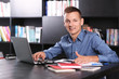 © Africa Studio - Handsome man with laptop studying in library