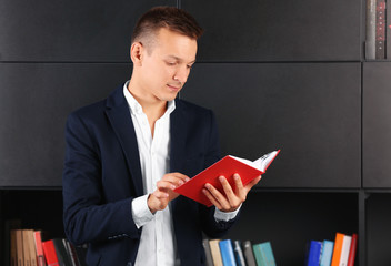 Poster - Handsome man reading book in library