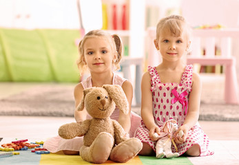 Poster - Cheerful little girls playing on floor