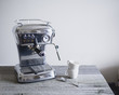 © Cavan Images - Espresso machine with coffee cups and spoon on table